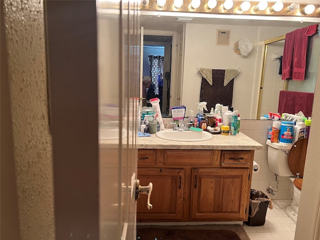 bathroom featuring toilet, tile floors, and vanity