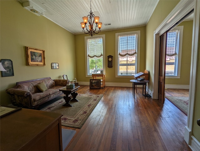 living room with crown molding, a notable chandelier, and dark hardwood / wood-style flooring