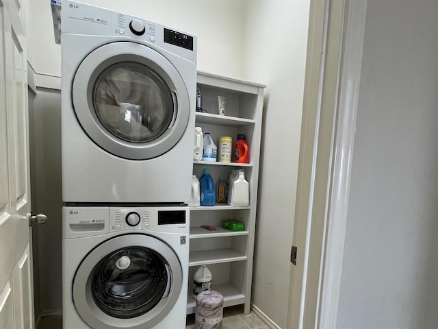 washroom with light tile floors and stacked washer and dryer