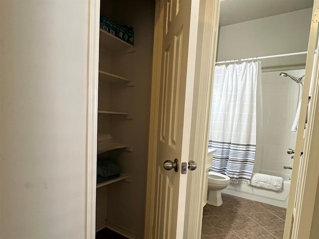 bathroom featuring toilet, tile flooring, and shower / tub combo