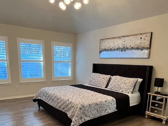 bedroom featuring dark hardwood / wood-style flooring and an inviting chandelier