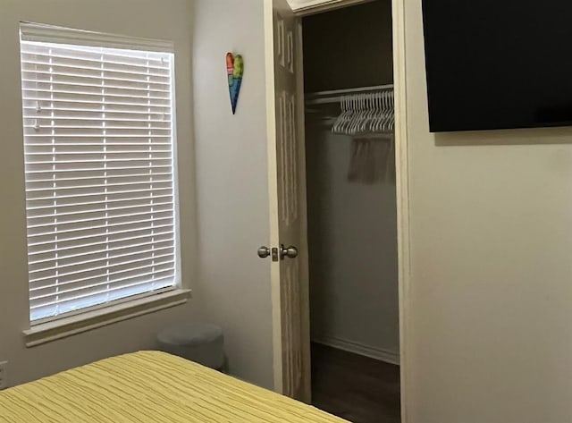 unfurnished bedroom with dark hardwood / wood-style flooring and a closet