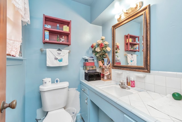 bathroom featuring backsplash, vanity with extensive cabinet space, and toilet