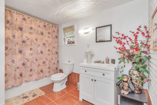 bathroom featuring toilet, vanity, and tile flooring