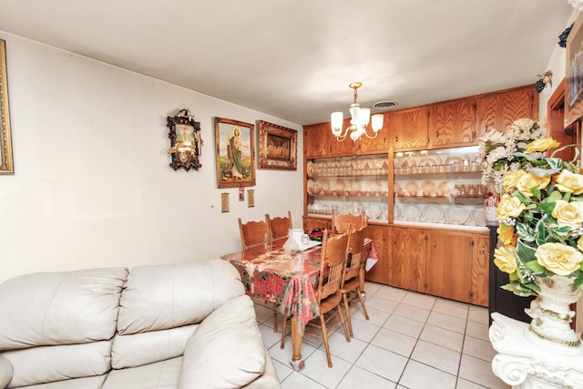 tiled dining room featuring an inviting chandelier