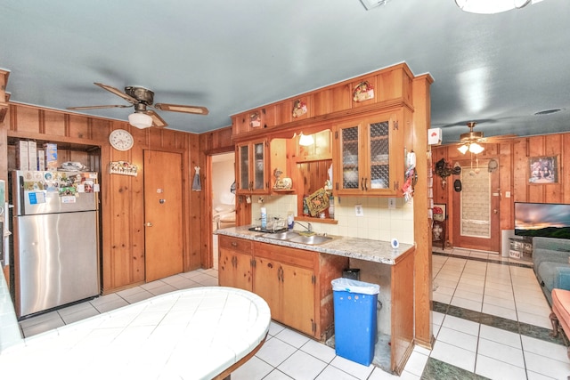 kitchen with light tile floors, ceiling fan, stainless steel refrigerator, and sink