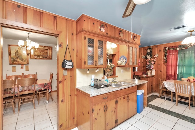 kitchen featuring light tile floors, hanging light fixtures, and ceiling fan with notable chandelier