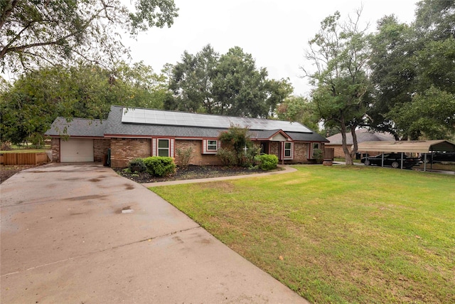 ranch-style house with a carport, a front lawn, solar panels, and a garage