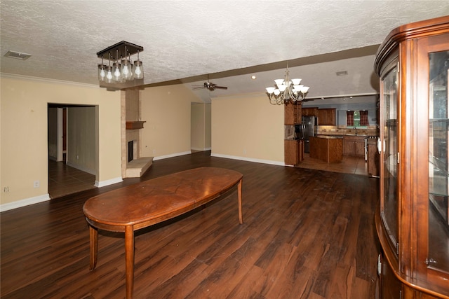 living room with a textured ceiling, a fireplace, ceiling fan with notable chandelier, and dark wood-type flooring