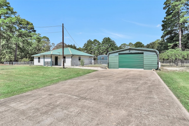 view of front of property featuring an outdoor structure, a garage, and a front yard