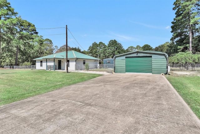 view of front facade featuring a garage, an outbuilding, and a front yard