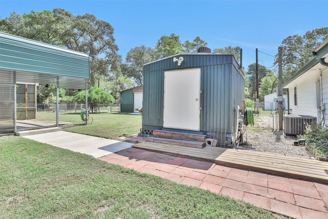 view of outbuilding with central air condition unit and a lawn