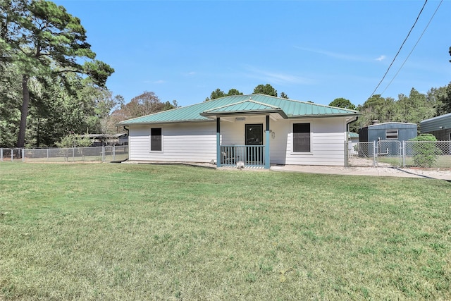 351 Trinity Dr, Trinity, TX 75862 - view of front facade with fence, a front yard, and metal roof