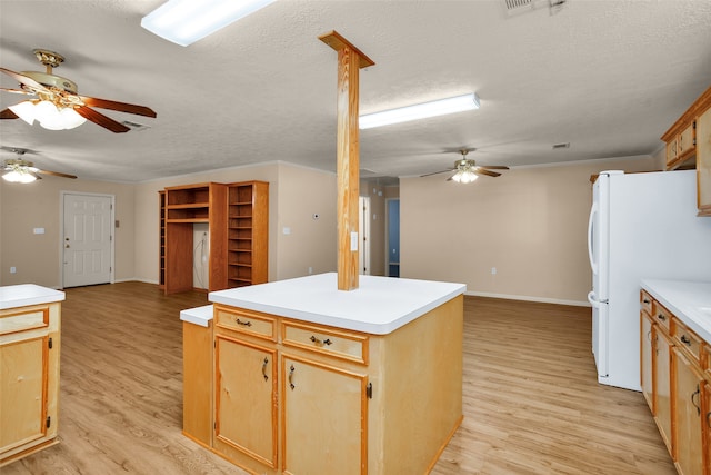 kitchen featuring a center island, white refrigerator, light hardwood / wood-style flooring, and ceiling fan