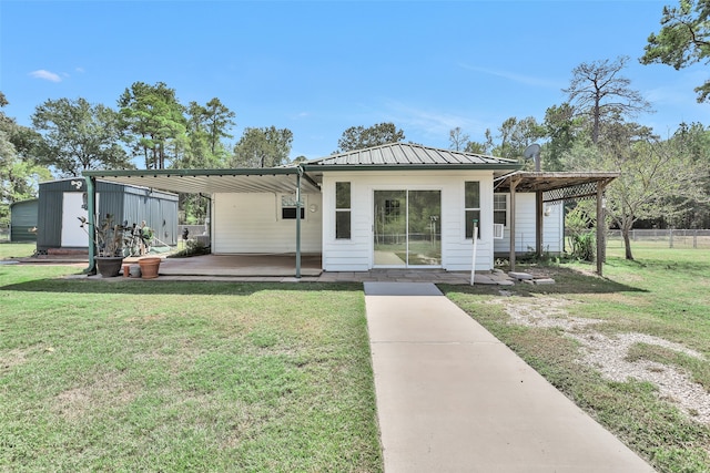 view of front of house featuring a carport, an outbuilding, and a front yard