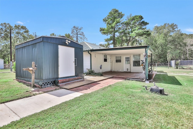 351 Trinity Dr, Trinity, TX 75862 - rear view of house featuring a deck, fence, an outdoor structure, a yard, and entry steps