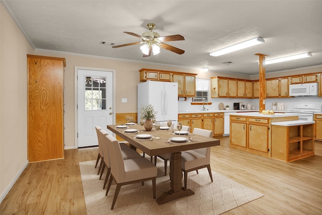 dining space featuring light hardwood / wood-style floors, sink, ornamental molding, and ceiling fan