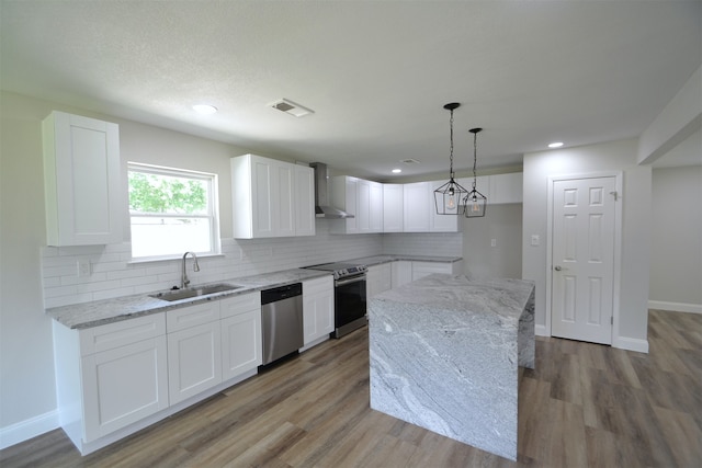 kitchen with sink, appliances with stainless steel finishes, light hardwood / wood-style flooring, and white cabinetry