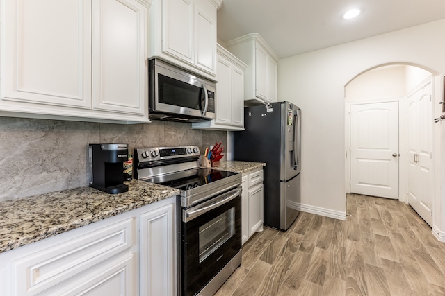 kitchen with light hardwood / wood-style floors, white cabinetry, tasteful backsplash, and stainless steel appliances