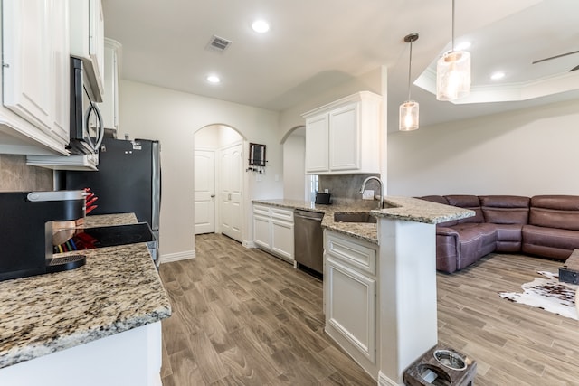 kitchen with decorative light fixtures, backsplash, light hardwood / wood-style floors, stainless steel appliances, and white cabinets