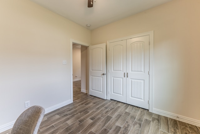 unfurnished bedroom featuring a closet, dark wood-type flooring, and ceiling fan