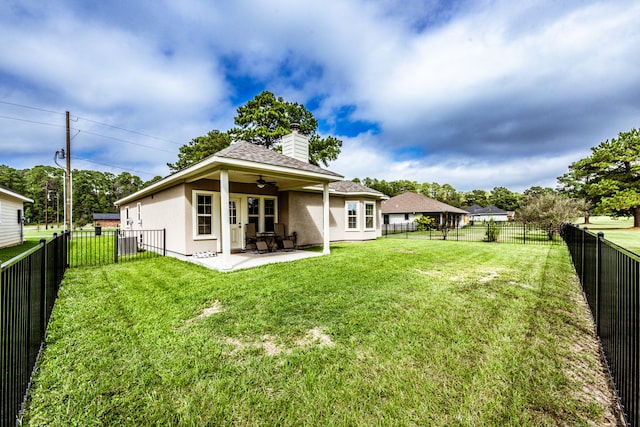 rear view of house featuring a patio, ceiling fan, and a yard