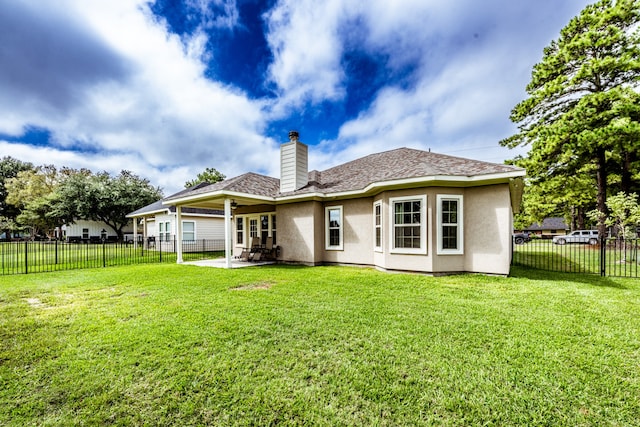 rear view of property featuring a lawn and a patio area