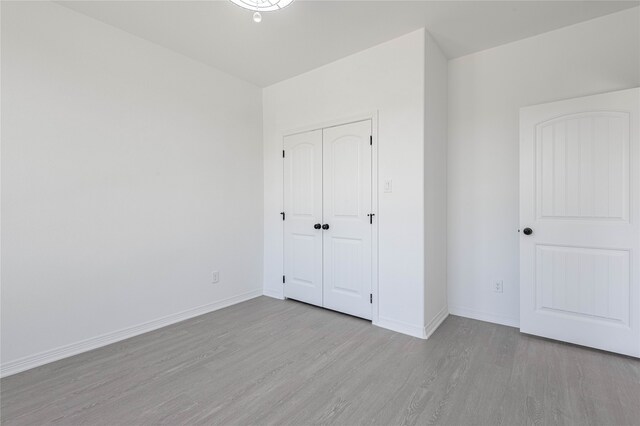 unfurnished bedroom featuring light hardwood / wood-style flooring and a closet