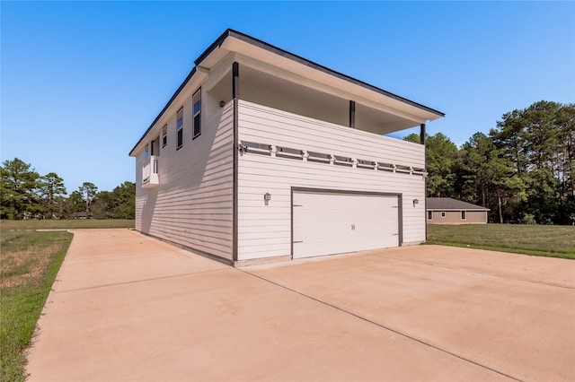 view of home's exterior featuring a garage and a lawn