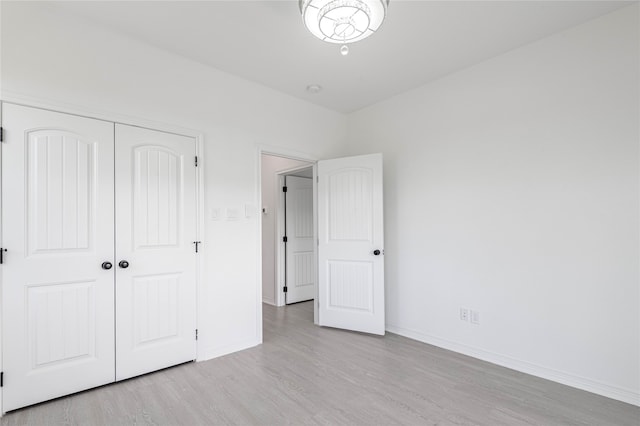 unfurnished bedroom featuring light hardwood / wood-style floors and a closet