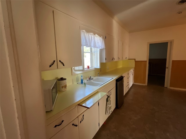 kitchen with white cabinetry, dishwasher, and sink