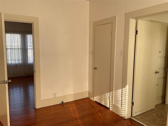 unfurnished bedroom featuring a closet and dark wood-type flooring