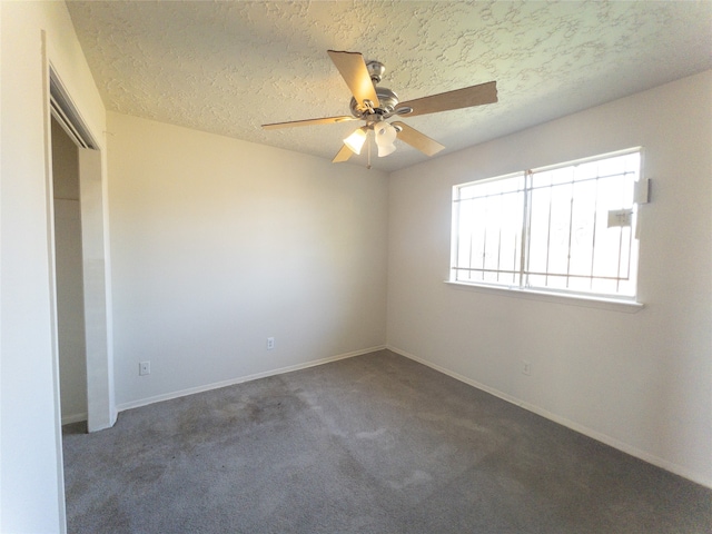 carpeted spare room featuring ceiling fan and a textured ceiling