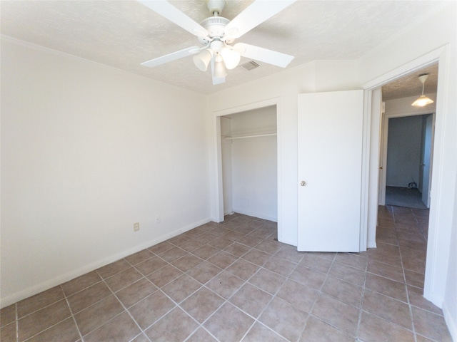 unfurnished bedroom featuring tile flooring, a closet, ceiling fan, and a textured ceiling