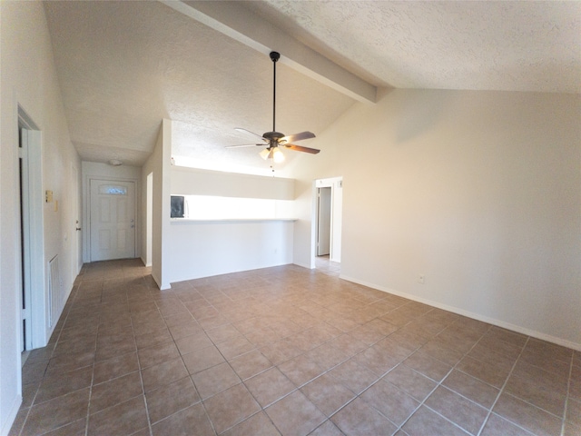 unfurnished living room featuring vaulted ceiling with beams, ceiling fan, and dark tile flooring