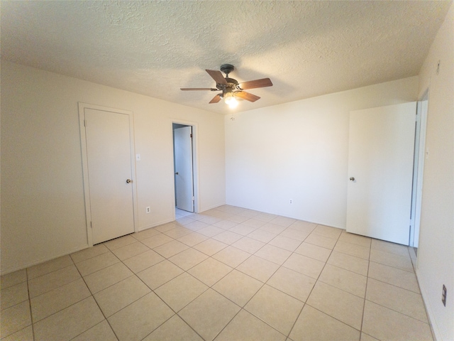 unfurnished bedroom featuring a textured ceiling, ceiling fan, and light tile floors