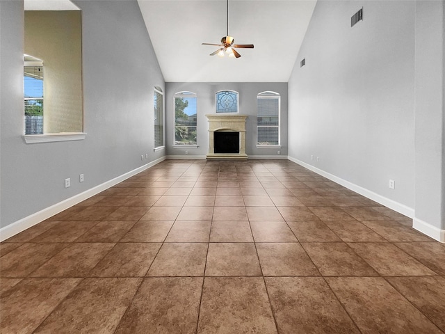 unfurnished living room featuring dark tile patterned floors, high vaulted ceiling, and ceiling fan