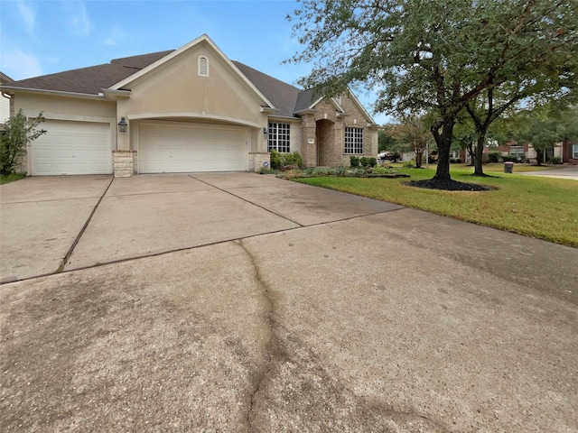 ranch-style home featuring a garage and a front lawn