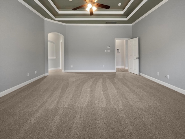 carpeted empty room featuring a tray ceiling, ornamental molding, and ceiling fan