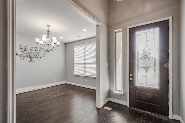 entryway with dark wood-type flooring and a notable chandelier