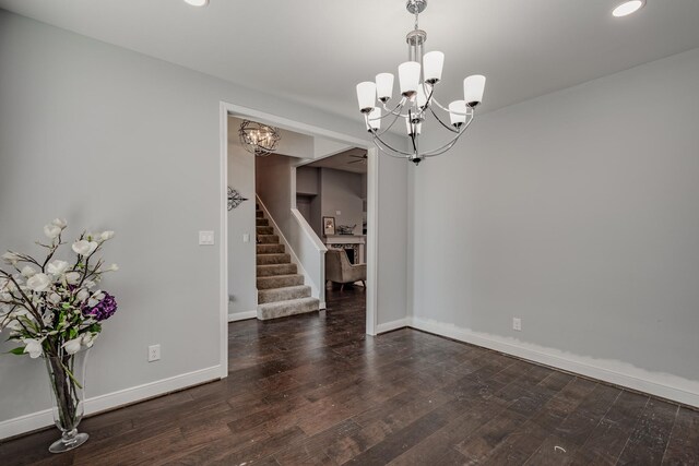 unfurnished room featuring an inviting chandelier and dark hardwood / wood-style flooring