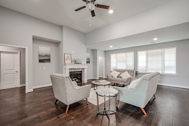 living room with ceiling fan, dark wood-type flooring, and a tile fireplace