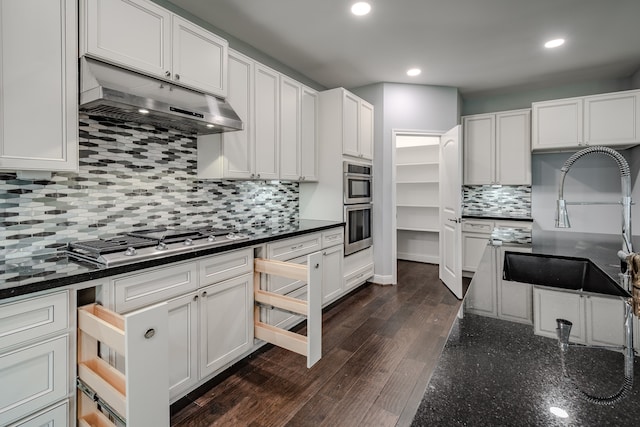 kitchen featuring dark hardwood / wood-style floors, sink, white cabinets, backsplash, and stainless steel appliances