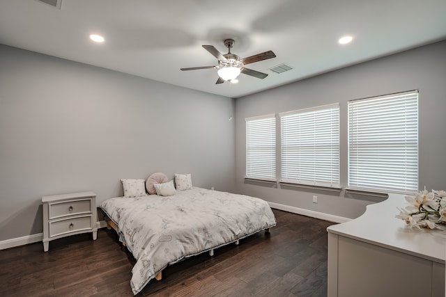 bedroom featuring multiple windows, dark hardwood / wood-style floors, and ceiling fan