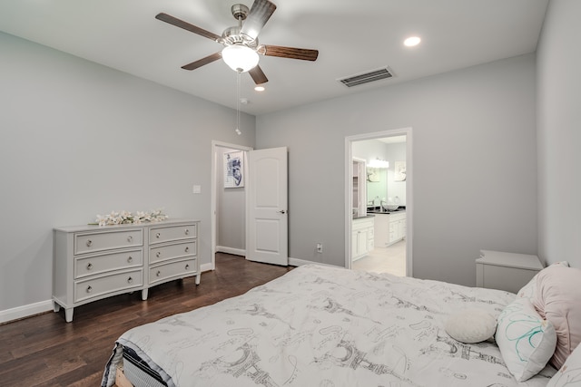 bedroom featuring ensuite bath, dark hardwood / wood-style flooring, and ceiling fan