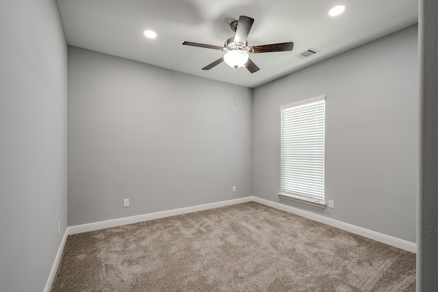 carpeted spare room featuring ceiling fan