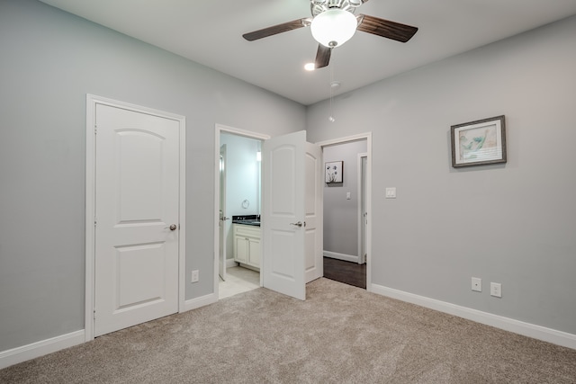 unfurnished bedroom with light carpet, connected bathroom, and ceiling fan