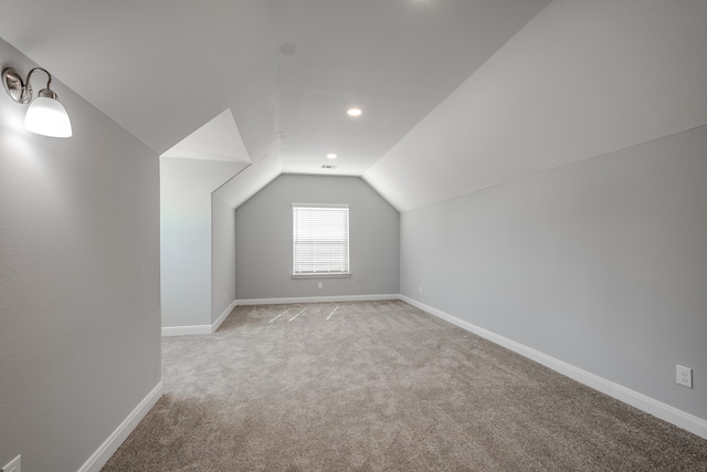 bonus room with light carpet and lofted ceiling