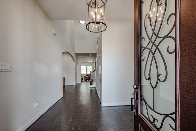 entrance foyer with an inviting chandelier, dark hardwood / wood-style floors, and a high ceiling