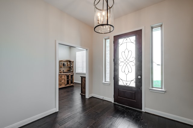 foyer entrance with a chandelier and dark hardwood / wood-style floors